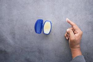 top view of man hand using petroleum jelly photo