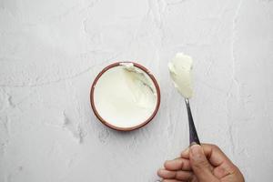 Top view of man's hand eating fresh yogurt from a bowl photo