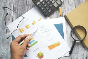 man hand with pen analyzing bar chart on paper photo