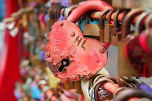 muchos candados de amor encerrados en una puerta de hierro oxidada en Singapur foto