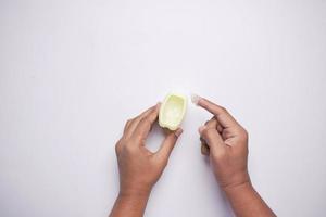 top view of man hand using petroleum jelly on white background photo