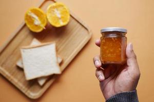 orange fruit spread in a container top view photo