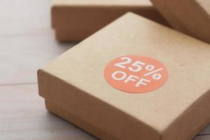 close up of 25 percent discount sign on a box on table photo