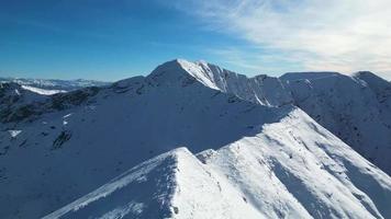 incrível vista de diferentes picos de montanha com neve durante o inverno. bela cordilheira e atração incrível para os alpinistas. estilo de vida aventureiro. cume de montanha desafiador para alpinistas. video