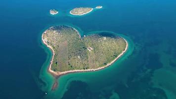 vista aérea drone de galesnjak a ilha do amor na croácia com água do mar azul turquesa linda. ilha em forma de coração. destino de viagens e férias. turismo incrível nas ilhas da croácia. video