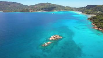 mahe seychelles, drone volant près du rivage, passant au-dessus des rochers au centre, se dirigeant vers l'île principale de mahe video