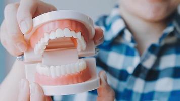 conceito de estomatologia, retrato parcial de menina com fortes dentes brancos, olhando para a câmera e sorrindo, dedos perto do rosto. closeup de jovem no dentista, estúdio, dentro de casa video