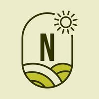 plantilla de emblema del logotipo de la letra n agricultura. granja agrícola, agroindustria, signo de granja ecológica con sol y símbolo de campo agrícola vector