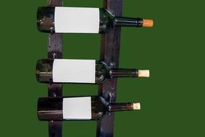 botellas aisladas de vino alineadas en el estante. el fondo es verde. enfoque suave y selectivo. foto