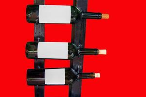 isolated Bottles of wine lined up on the shelf. The background is red. Soft and selective focus. photo