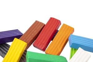 Multicolored plasticine, kids plasticine in the form of cubes and strips. White isolated background. photo