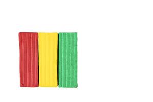 Multicolored plasticine, kids plasticine in the form of cubes and strips. White isolated background. photo
