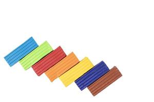 Multicolored plasticine, kids plasticine in the form of cubes and strips. White isolated background. photo