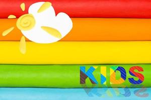 A plasticine rainbow with a sun and a cloud. Multicolored rainbow. Multicolored kids background. photo