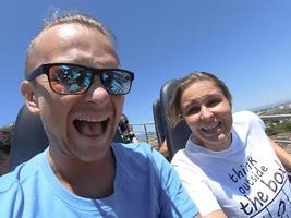 Man and woman on a roller coaster ride with emotion on their faces. photo