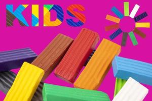 Multicolored kids' plasticine, the word kids, written in plasticine letters. purple background. photo