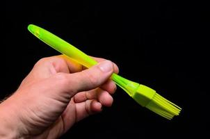 Hand holding a brush on black background photo