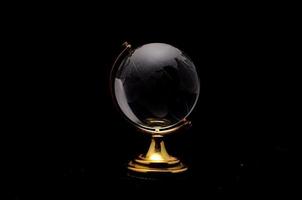 Glass globe on black background photo