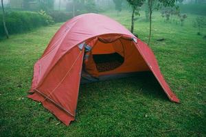 Red tent on the garden grass with foggy background photo