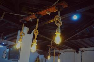 Edison lamp hanging on a rope and board. Nice decoration lightning bulbs. photo