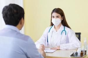 doctora asiática haciendo preguntas al paciente foto