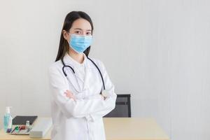 una doctora asiática usa una mascarilla médica foto