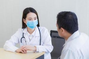 doctora asiática haciendo preguntas al paciente foto