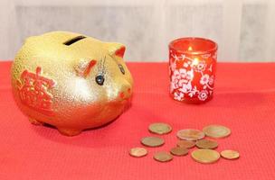 piggy bank, coins and a burning red candle photo