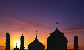 Silhouette mosque dome against colorful sunset sky in evening time during iftar period in Ramadan Holy month photo