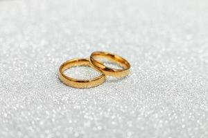 Will you marry me. Two golden wedding rings on silver glitter background. Engagement marriage proposal wedding concept. St. Valentine's Day postcard. Banner on valentines day. Copy space. photo