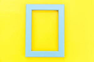 Simply design with empty blue frame isolated on yellow colourful trendy background. Top view, flat lay, copy space, mock up. Minimal concept. photo