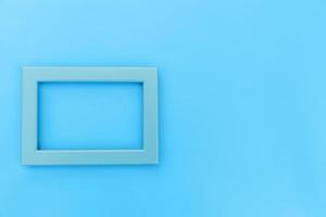 Simply design with empty blue frame isolated on blue pastel colorful background. Top view, flat lay, copy space, mock up. Minimal concept. photo