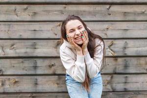 Happy girl smiling. Beauty portrait young happy positive laughing brunette woman on wooden wall background photo