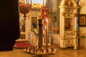 Iglesia Ortodoxa. cristiandad. decoración interior festiva con velas encendidas e icono en la iglesia ortodoxa tradicional en vísperas de pascua o navidad. religión fe orar símbolo. foto