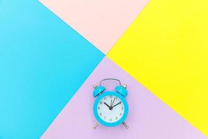 Ringing twin bell classic alarm clock isolated on blue yellow pink pastel colorful geometric background. Rest hours time of life good morning night wake up awake concept. Flat lay top view copy space. photo