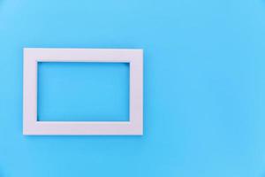 Simply design with empty pink frame isolated on blue pastel colorful background. Top view, flat lay, copy space, mock up. Minimal concept. photo