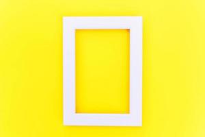 Simply design with empty pink frame isolated on yellow colourful trendy background. Top view, flat lay, copy space, mock up. Minimal concept. photo