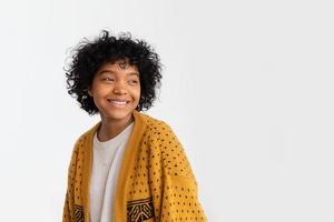 Beautiful african american girl with afro hairstyle smiling isolated on white background with copy space. Young african woman with curly hair laughing. Freedom happiness carefree happy people concept. photo