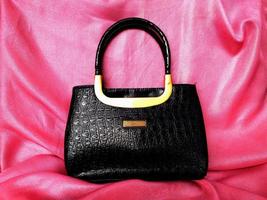 Black handmade women's shopper bag, patent leather bag made of crocodile. The black crocodile skin bag looks elegant and luxurious but still simple, perfect for going to parties or invitations photo