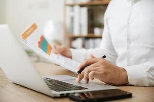 Businessman analyzing company's financial balance sheet working with digital augmented reality graphics. Businessman calculates financial data for long-term investment. photo