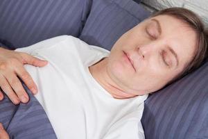 concepto de paz. hombre guapo durmiendo en la cama foto