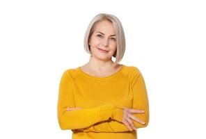 rubia de mediana edad posando emocionalmente en un estudio. mujer feliz en suéter amarillo brillante sobre fondo blanco foto