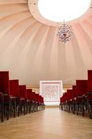 hall and empty stage, many rows of red chairs and festive velvet stage photo