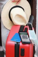 a passport and a smart phone with a certificate of vaccination against the Covid-19 disease. focus on the smart phone. Health Passport concept. travel the world. photo