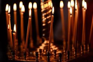 burning candles in church on dark background photo