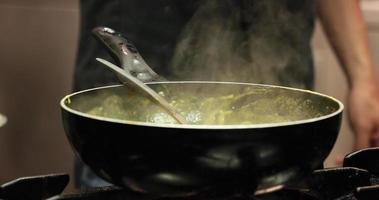 Dampf, der aus der Soße aufsteigt, die in einer Soßenpfanne in der Küche gekocht wird. - Nahaufnahme video