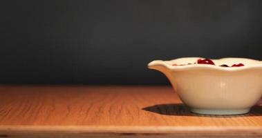 Hand Pushing A While Bowl With Cereals And Fruit Berries On A Wooden Table - Slow Motion video