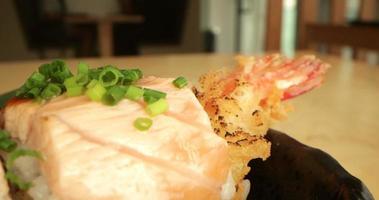 salmone Sushi rotoli con gamberetto tempura Riempimento, sormontato con tritato fresco verde erba cipollina - macro, lento puntamento tiro video