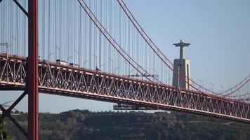 veicoli in viaggio su il bellissimo abril sospensione ponte nel Portogallo di il grande statua di Gesù Cristo - largo tiro video