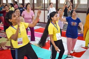 Delhi, India, June 19 2022 -Group Yoga Aerobics session for people of different age groups in Balaji Temple, Vivek Vihar, International Yoga Day, Big group of adults attending aerobics class in temple photo